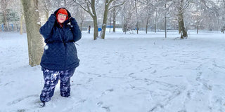 A plus size woman wearing plus size outerwear while modeling in the snow
