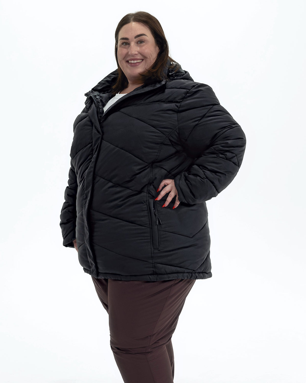 Black Geneva women's plus size mid length synthetic down jacket, three quarter view, hand on hip