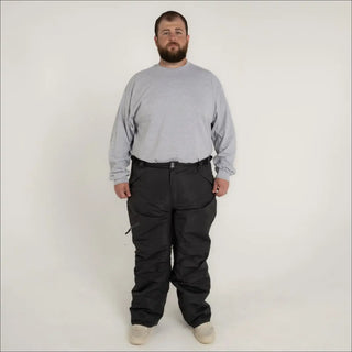 Man wearing gray long-sleeve shirt and black insulated snow pants for skiing