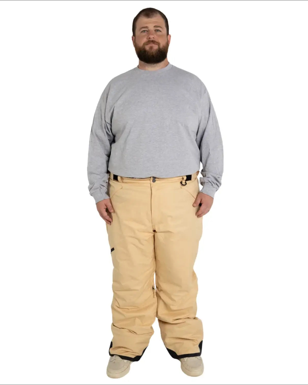 Man wearing tan snow pants and gray shirt in Snow Country Outerwear ski gear