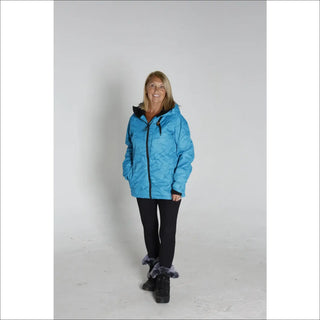 Woman wearing a blue quilted Snow Country Outerwear winter ski coat jacket