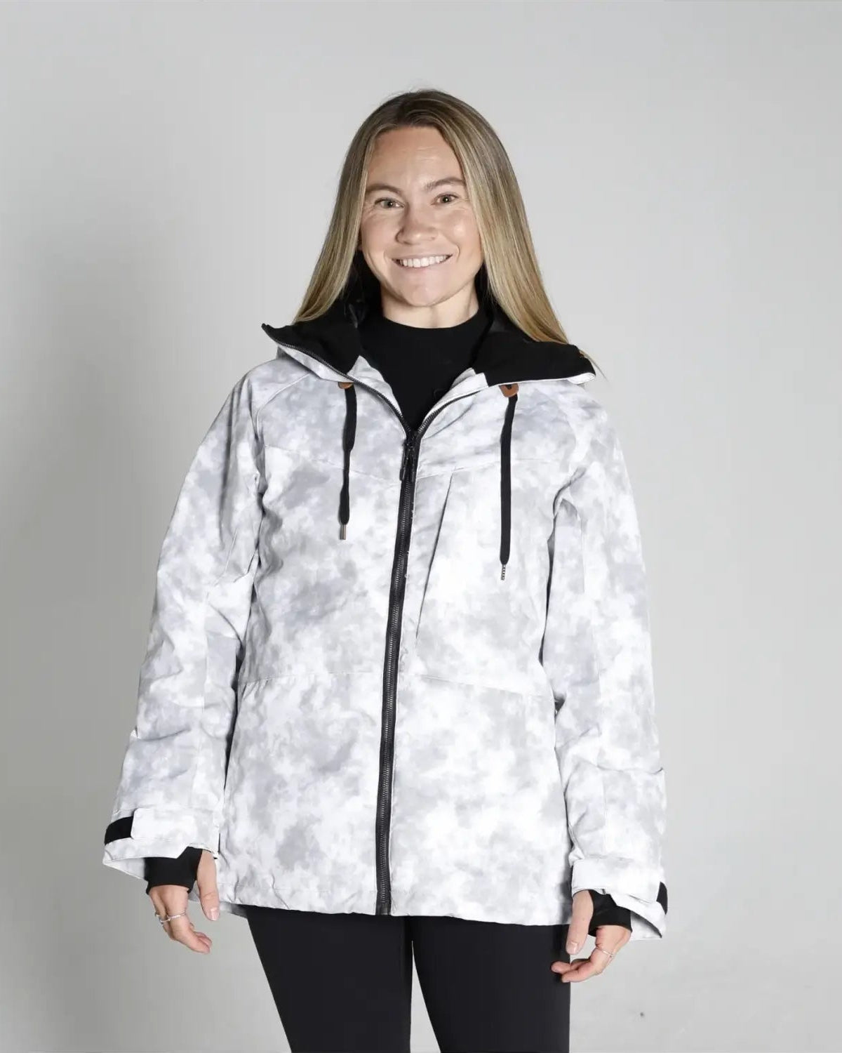 Woman wearing a white camouflage jacket from Snow Country Outerwear for snowboarding and winter skiing