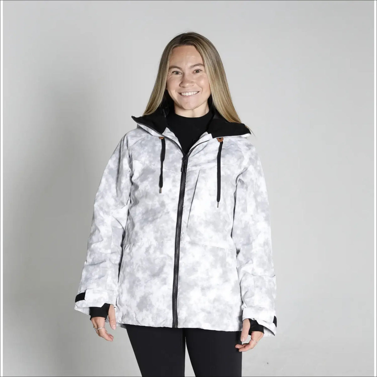 Woman wearing a white camouflage jacket from Snow Country Outerwear for snowboarding and winter skiing