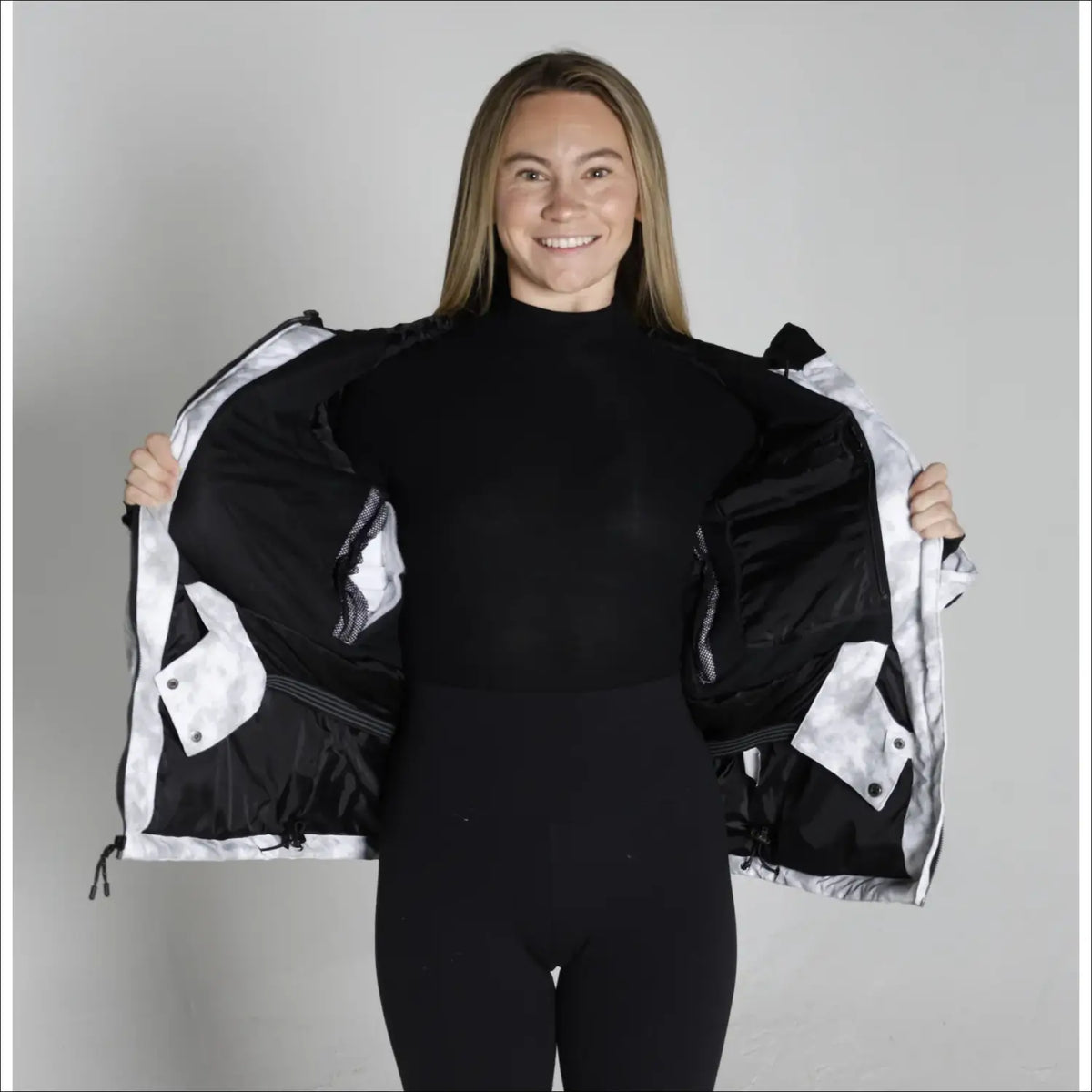 Woman showing the inside of a White and Black Snow Country Womens Ski Coat Jacket