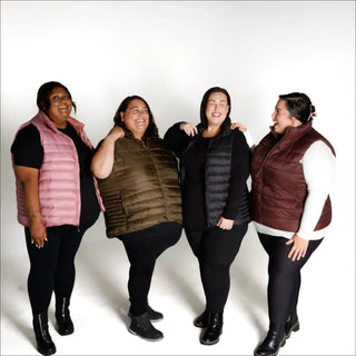 Four women wearing stylish plus size synthetic down vests in various colors