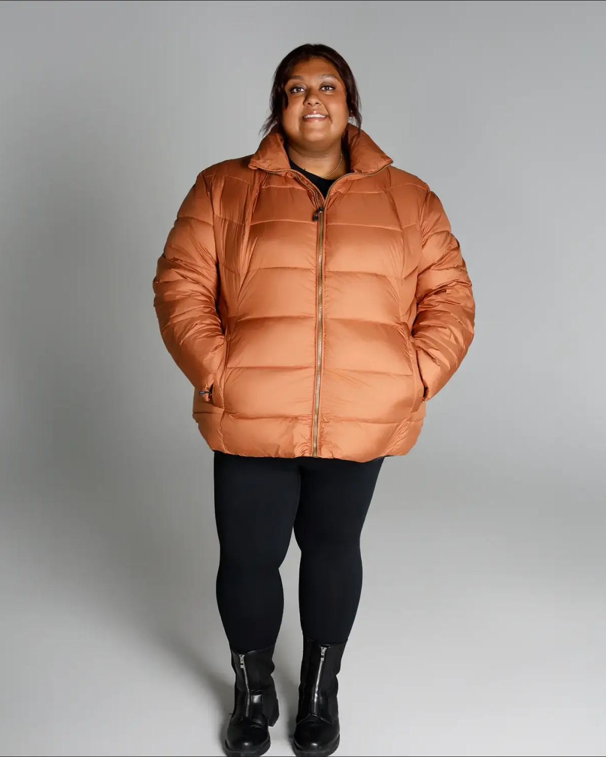 Woman wearing a puffy orange Lexington Synthetic Winter Jacket from Snow Country Outerwear