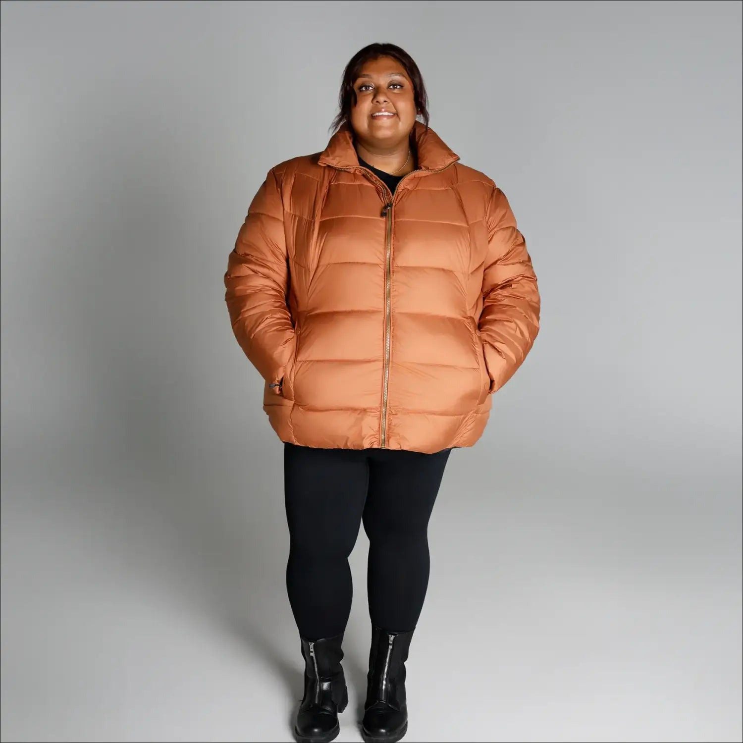 Woman wearing a puffy orange Lexington Synthetic Winter Jacket from Snow Country Outerwear