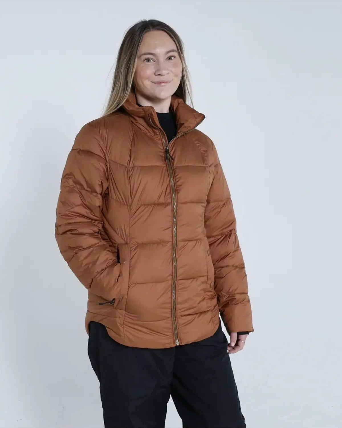 Woman wearing a brown puffer jacket from Snow Country Outerwear Lexington collection