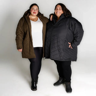 Two women wearing oversized plus size winter parkas in a seasonal outdoor setting