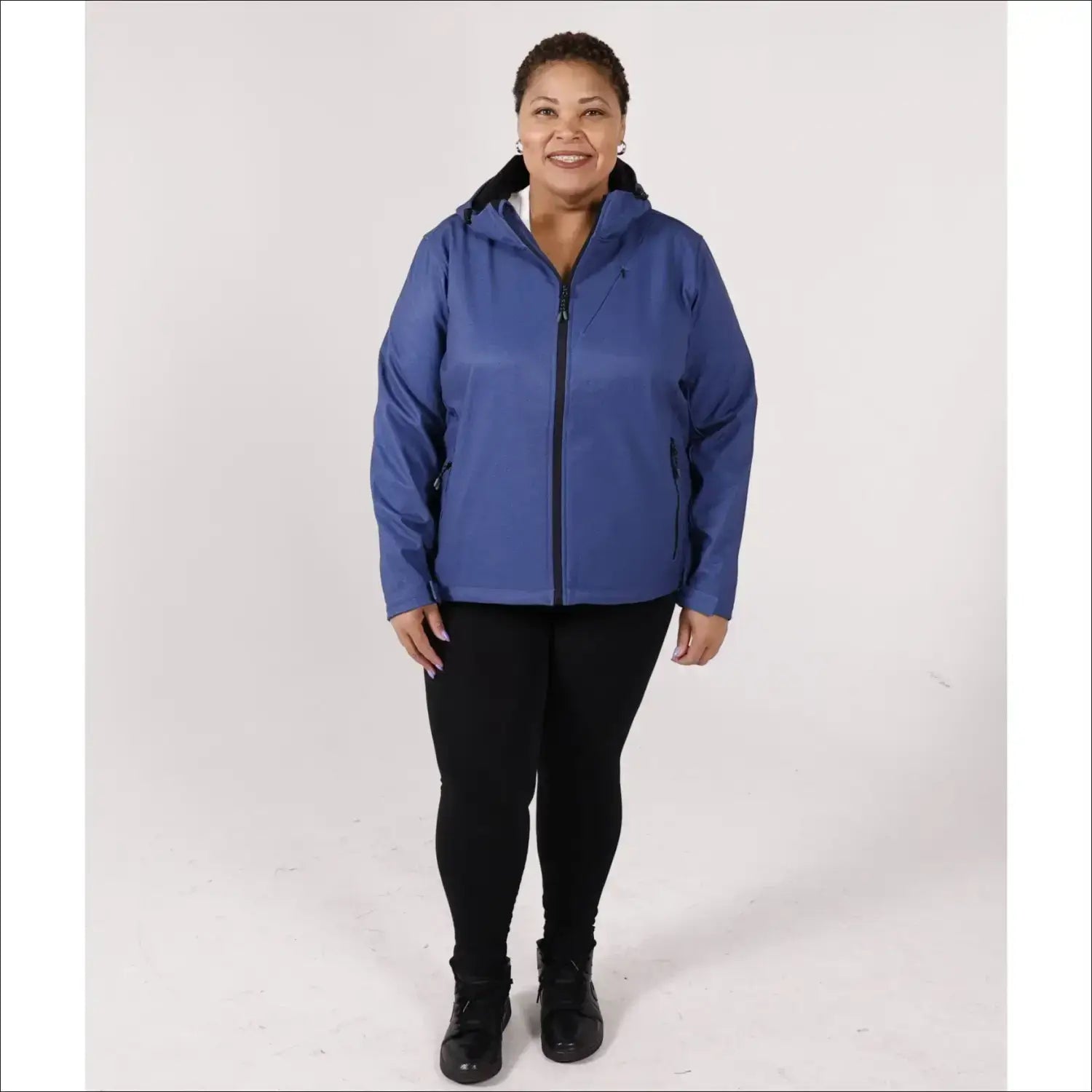 Woman in blue hooded plus size fleece soft shell jacket with black leggings and boots