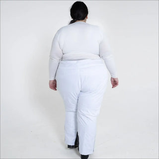 Woman in white winter skiing outfit wearing insulated snow ski pants outdoor scene