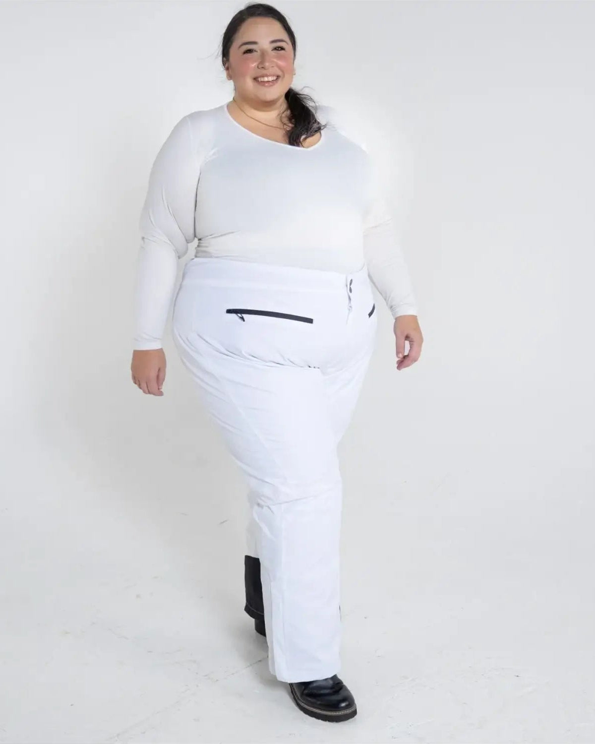 Woman in white plus size insulated ski pants and top for winter snow sports