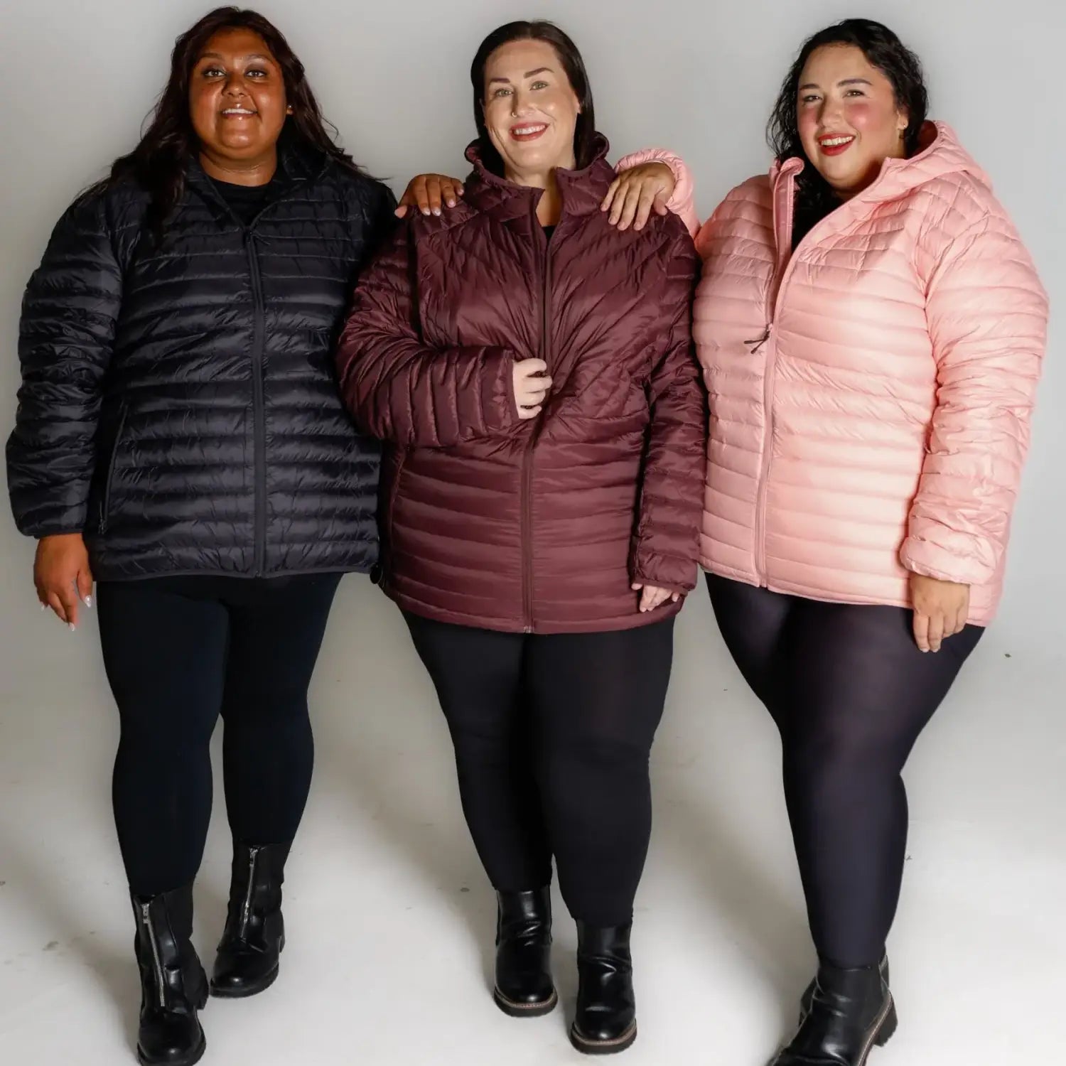 Three women wearing puffy packable down jackets in snow country outerwear scene