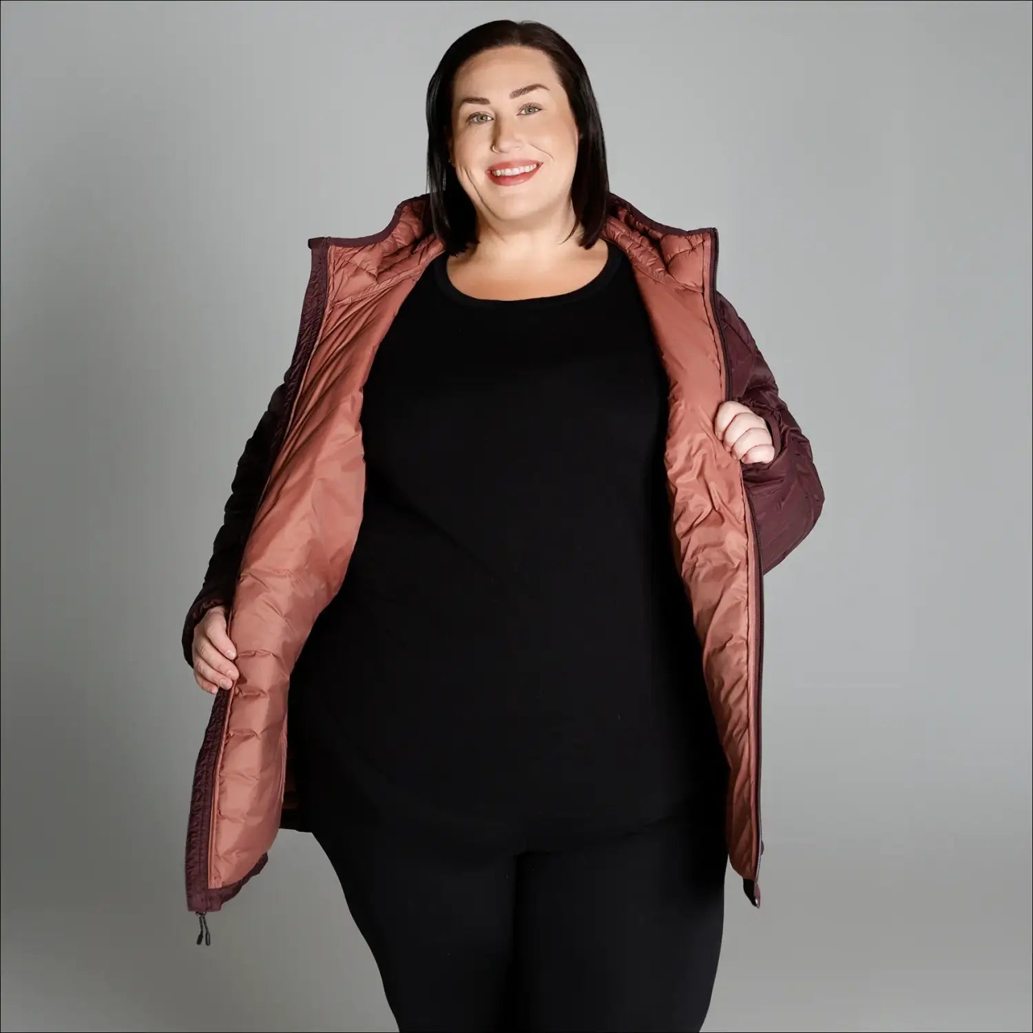 Woman wearing an open quilted packable down hooded coat ideal for snow country outdoor wear