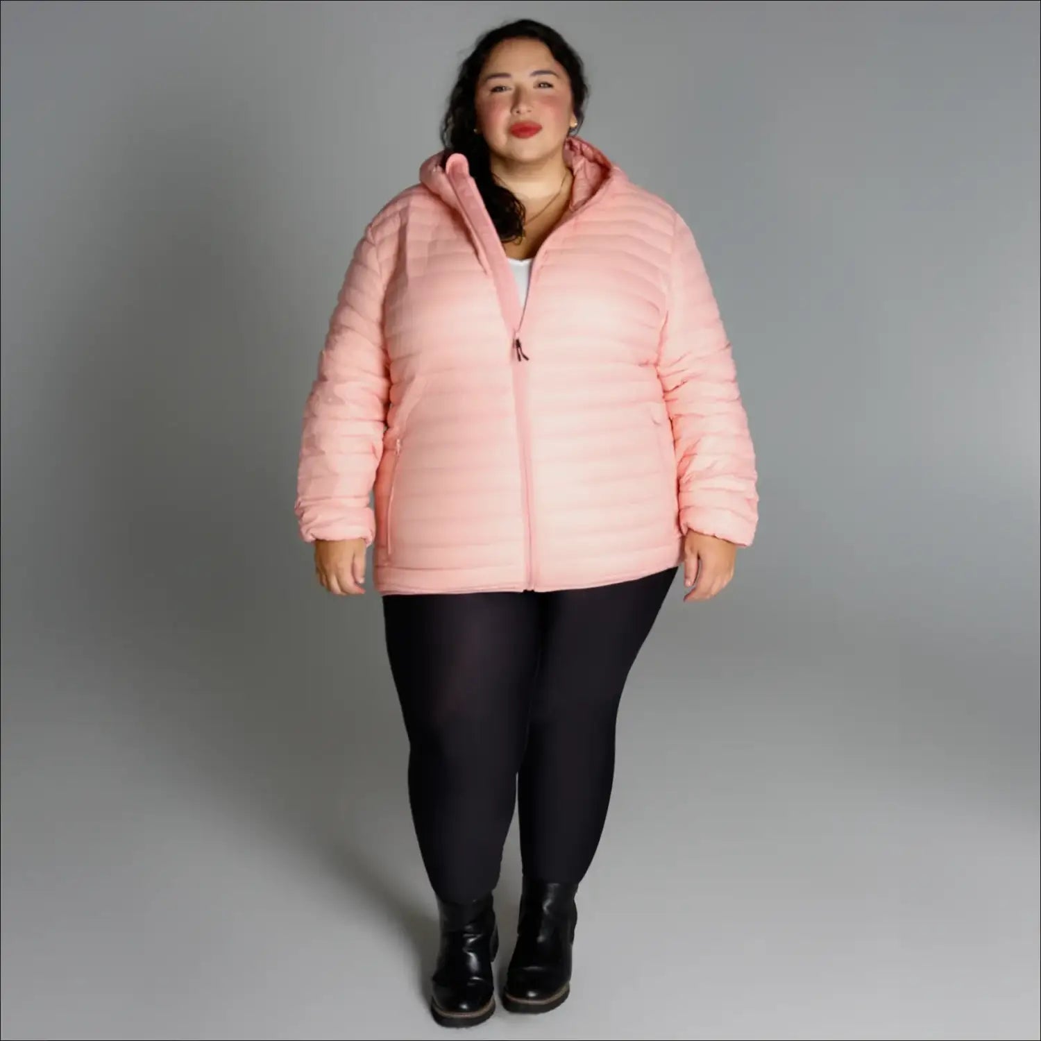 Woman wearing a pink puffer jacket from the Women’s Plus Extended Size Packable Down Coat collection