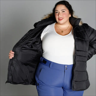 Woman in black puffer jacket and blue ski pants wearing Snow Country Outerwear Luna winter coat