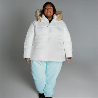Woman in white puffer jacket and light blue pants wearing Snow Country Outerwear Luna ski coat