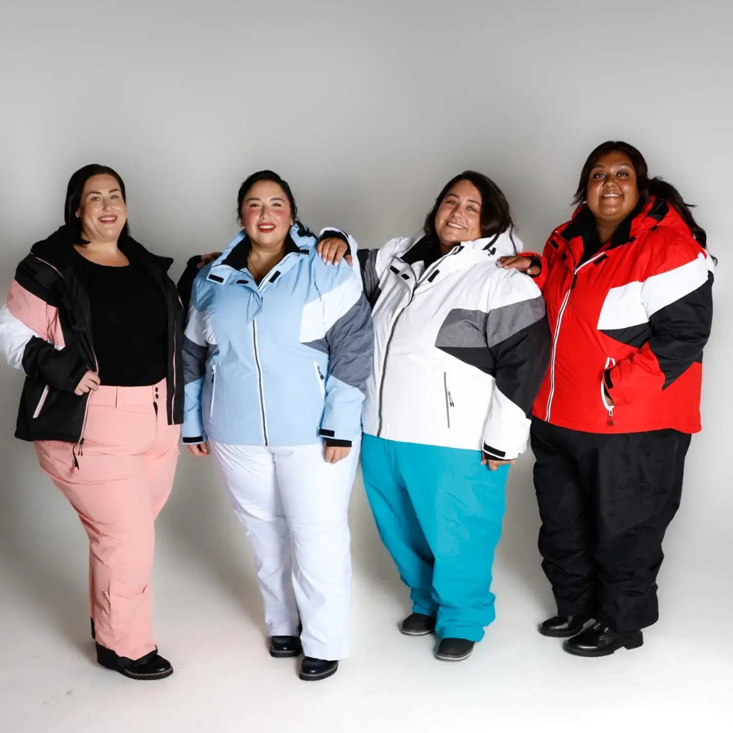 Four women in colorful Ski outfits wearing Snow Country Plus Size Winter Jackets