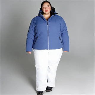Woman in blue puffer jacket and white pants wearing Snow Country Outerwear Womens Plus Size Vail Ski Coat