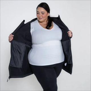 Woman in black plus size Stowe soft shell jacket with pockets showcasing product style