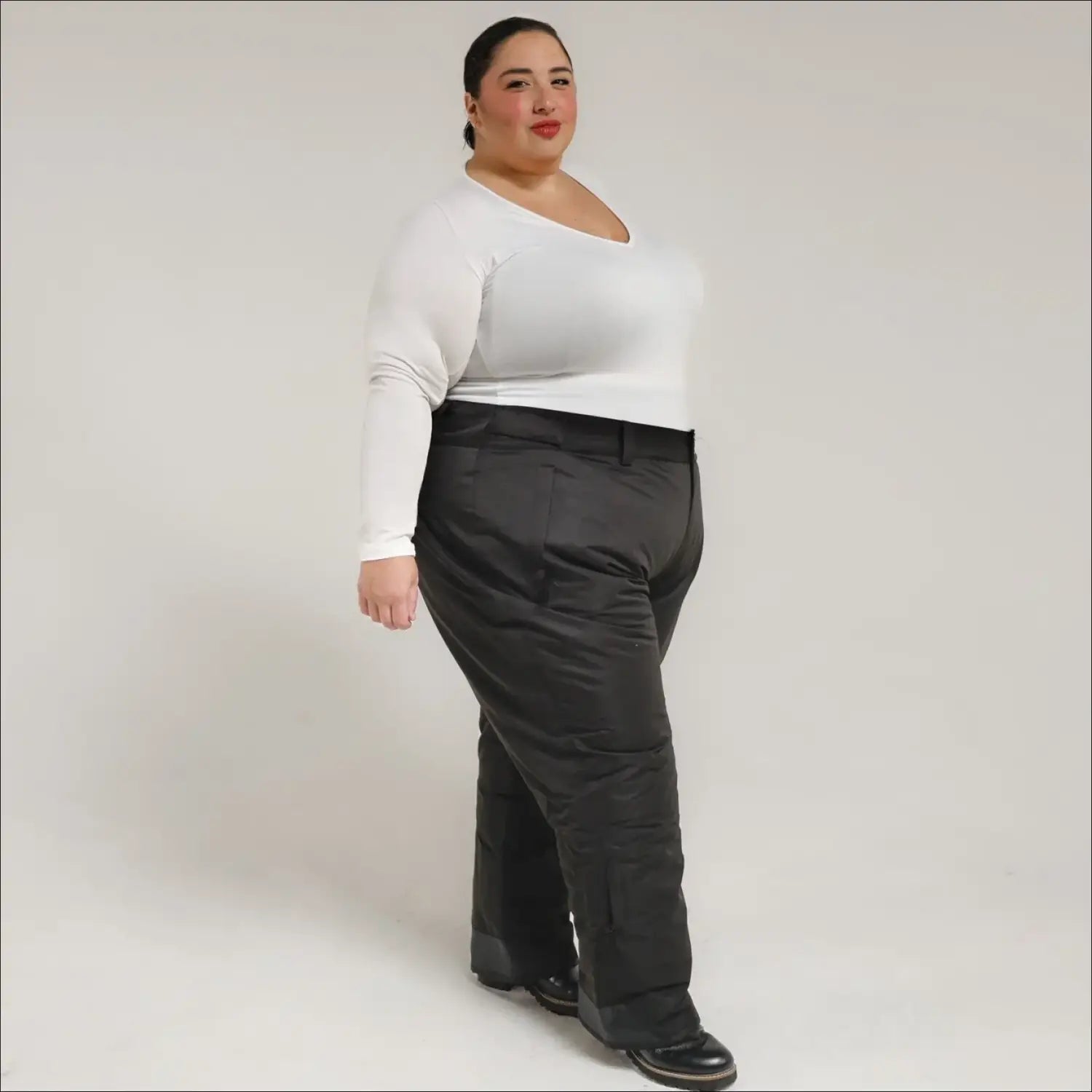 Woman wearing a white top and black pants showcasing Snow Country Plus Size Insulated Ski Pants