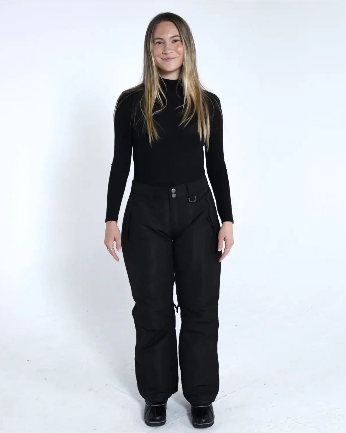 Woman wearing black ski pants and turtleneck from Snow Country Outerwear Ski Collection