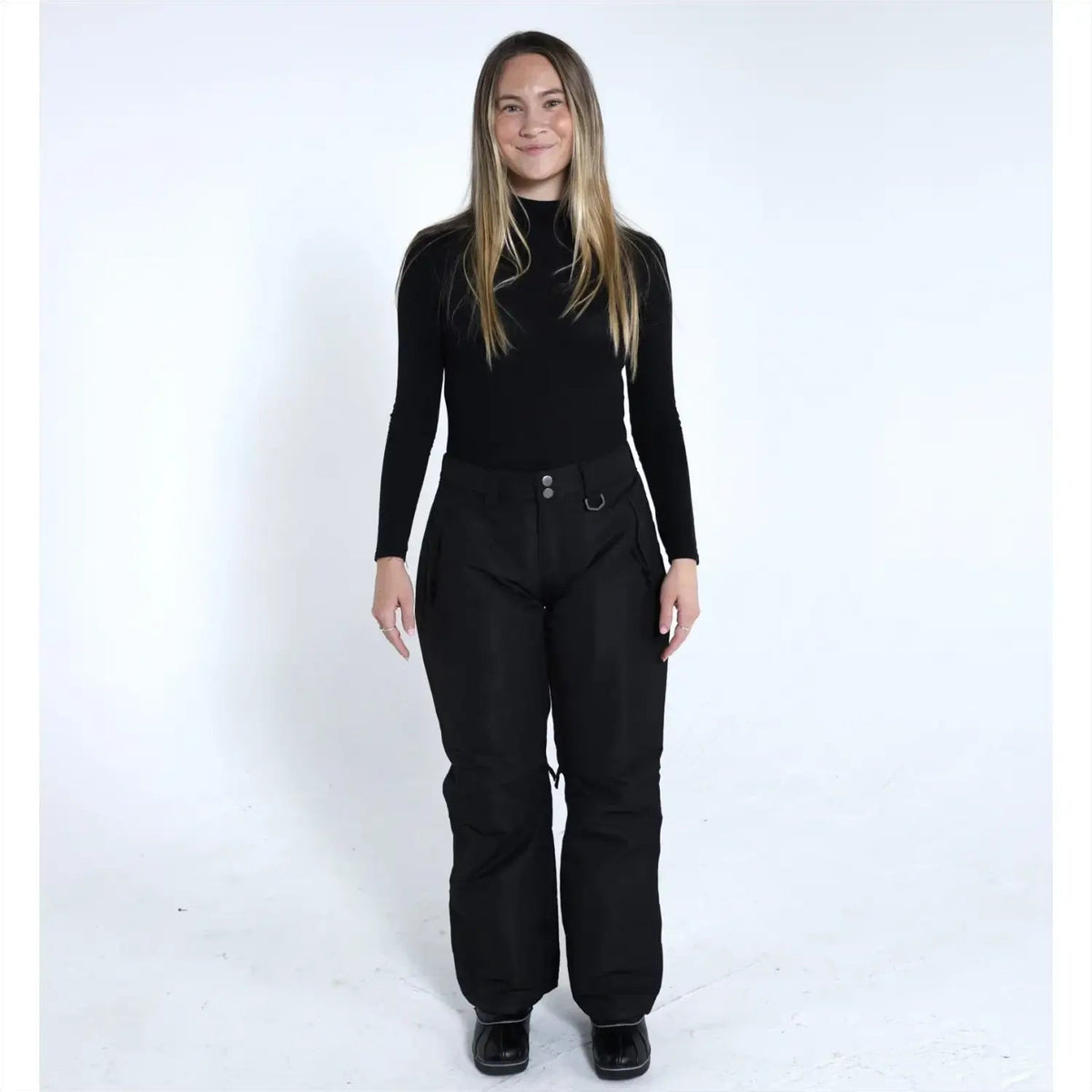 Woman wearing black ski pants and turtleneck from Snow Country Outerwear Ski Collection