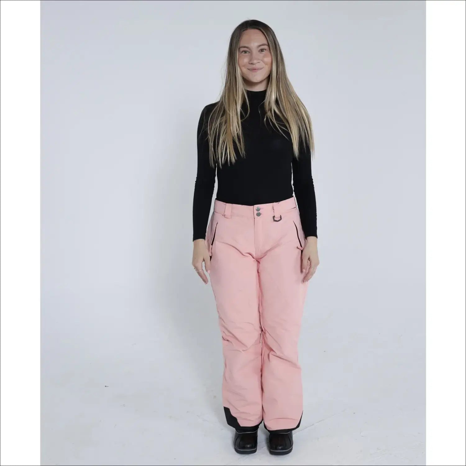 Woman in pink snow pants and black turtleneck wearing Snow Country Ski Pants