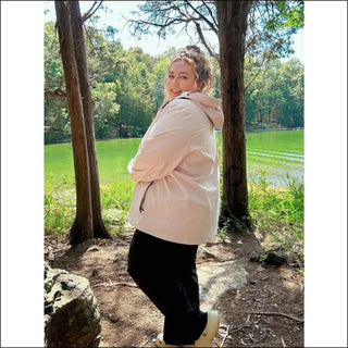 Woman in a light pink hooded waterproof rain jacket Camden Spring Fall collection