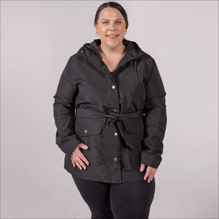 Woman wearing black belted hooded rain jacket from Snow Country Outerwear in plus size