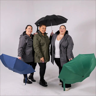 Three women in raincoats with umbrellas showcasing Women’s Plus Size Rain Jacket Trench Coat Berwick