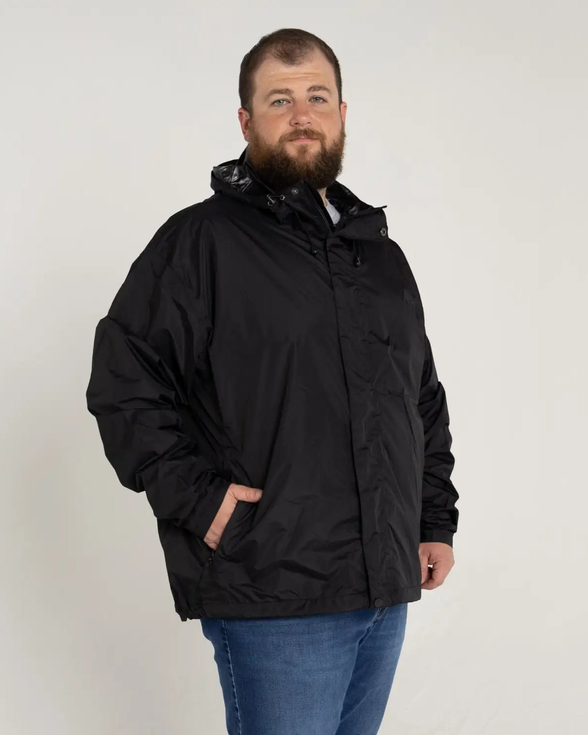 Man wearing black Snow Country Outerwear packable hooded rain jacket in big sizes