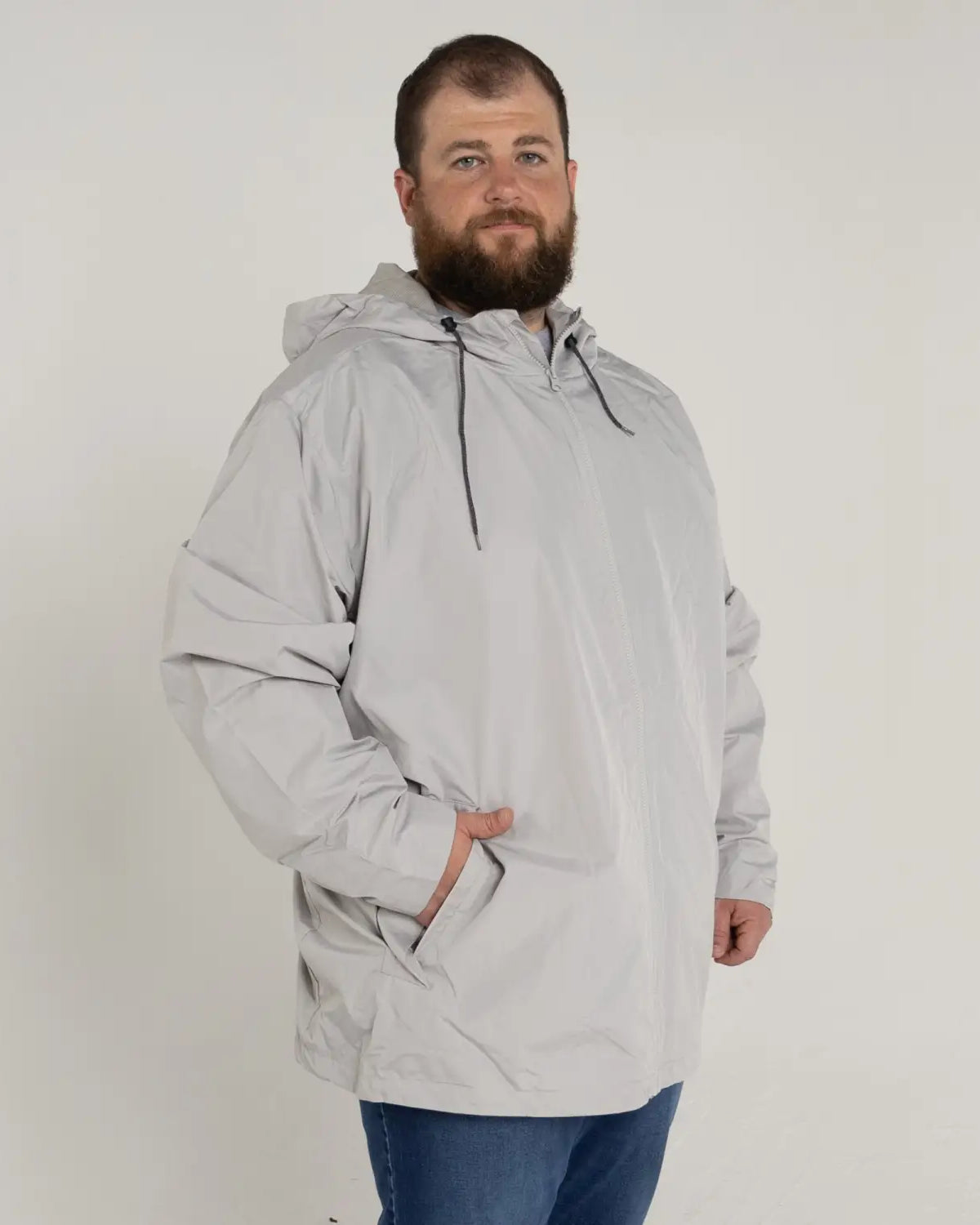 Man wearing a gray hooded anorak from Men’s Big 3XL-7XL Rain Jacket Windguard Coat