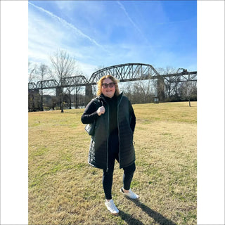 Plus size woman wearing black vest and leggings in insulated outerwear fashion setting