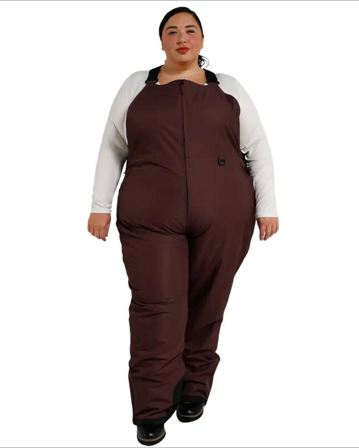 Woman wearing brown insulated bib overalls from Snow Country Outerwear for skiing