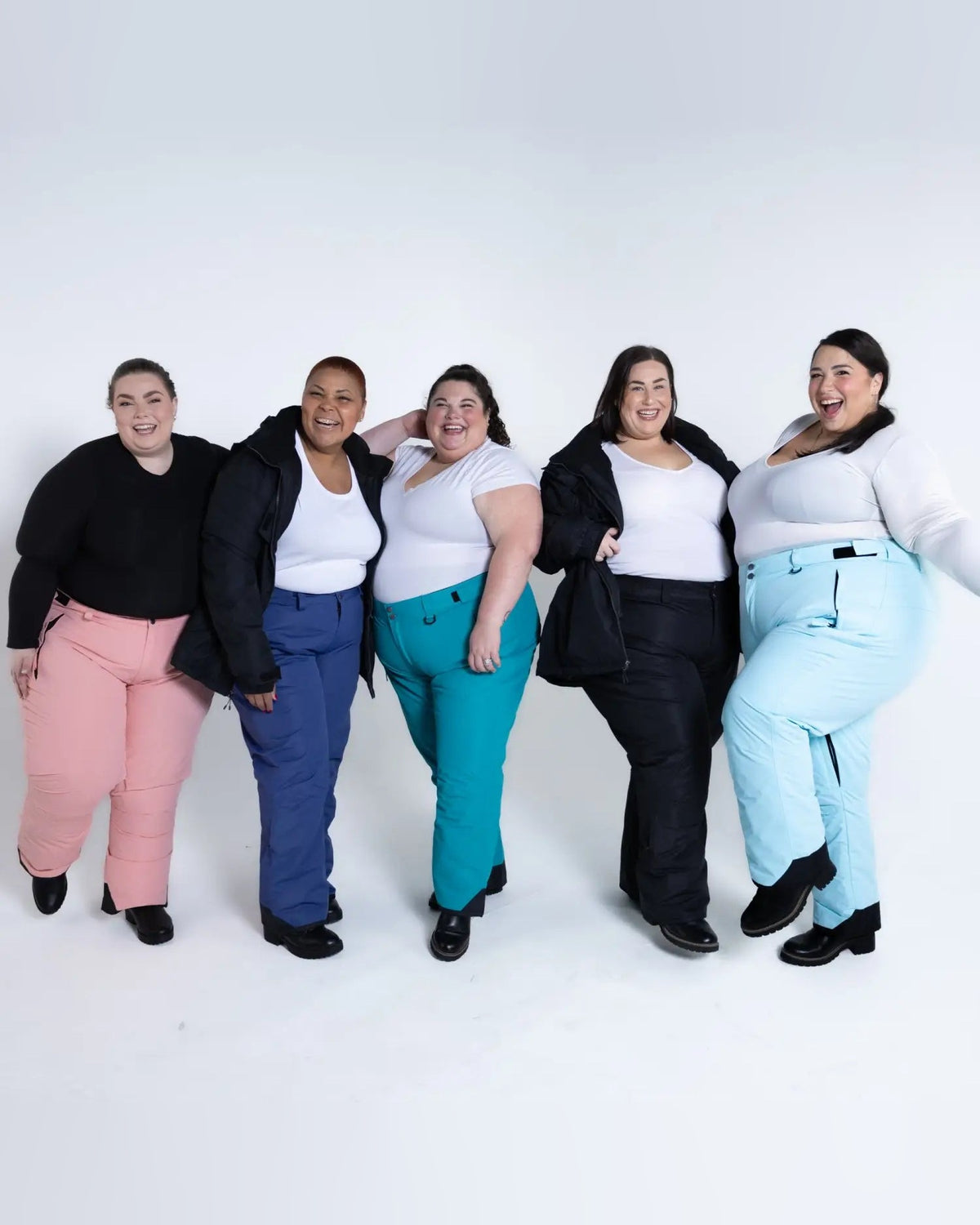 Plus-size women wearing colorful Snow Country insulated ski pants for winter outdoor activities