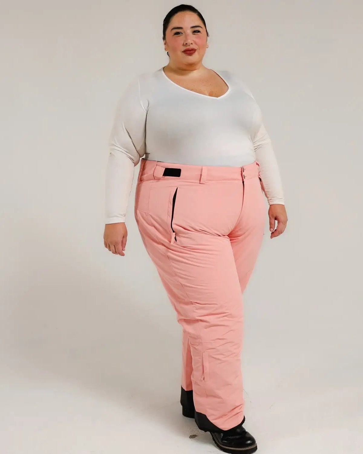 Woman wearing pink Snow Country insulated ski pants in a winter outdoor setting