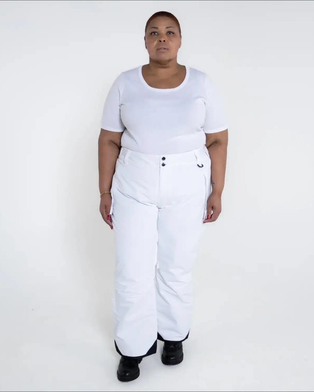 Woman wearing white insulated ski pants in Snow Country Outerwear Plus Size collection