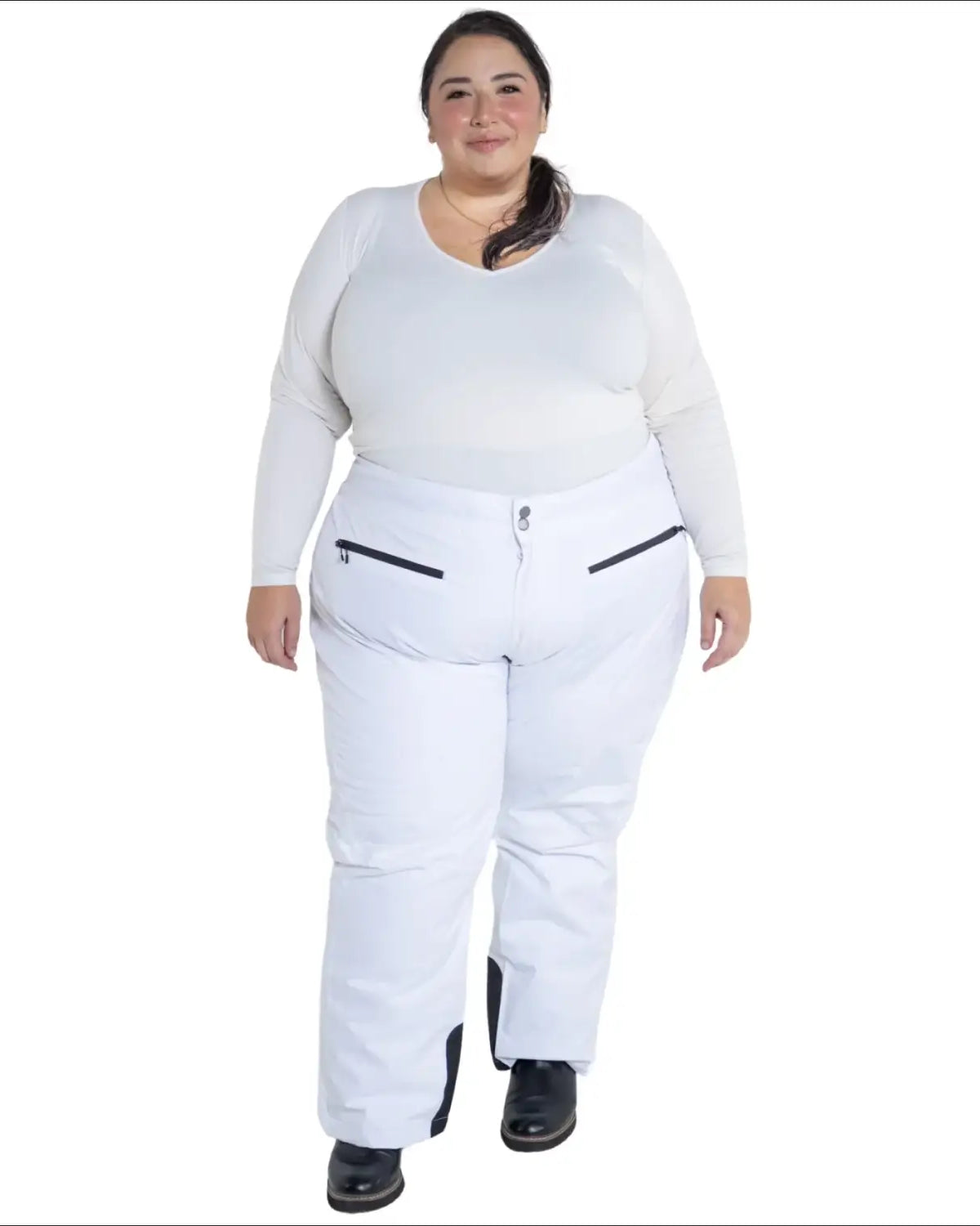 Plus-size woman in white insulated ski pants and long-sleeved shirt for winter skiing