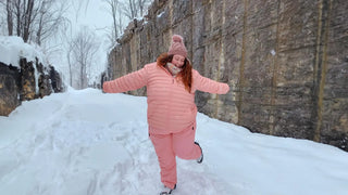 A woman wearing a plus size winter coat posing in the snow