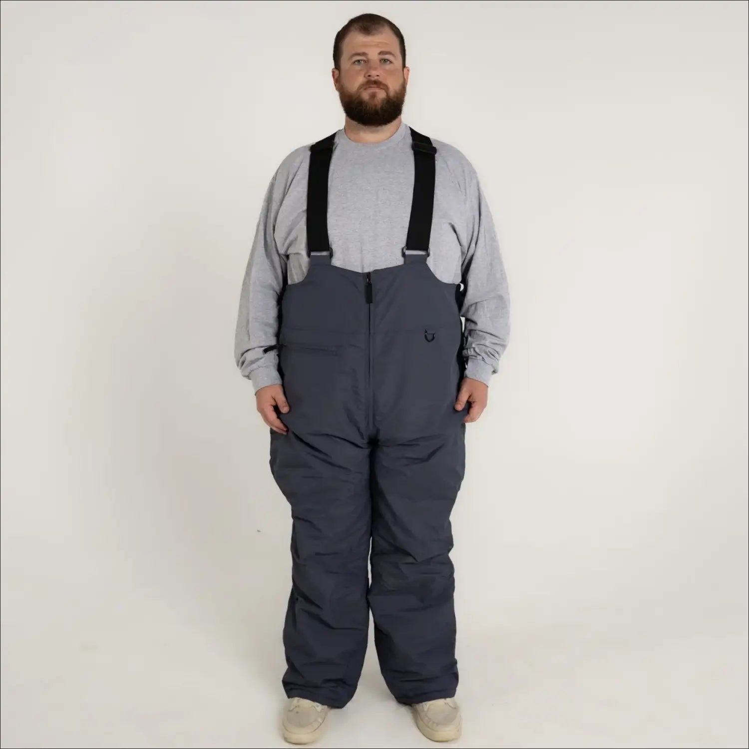 Man wearing gray Snow Country Outerwear insulated ski snow bibs with suspenders