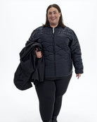 Black Swiss Systems women's plus size 3 in 1 winter jacket, quilted liner jacket with the shell over her arm