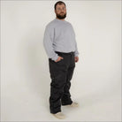 Man wearing gray sweatshirt and black pants in Snow Country Outerwear ski snow pants