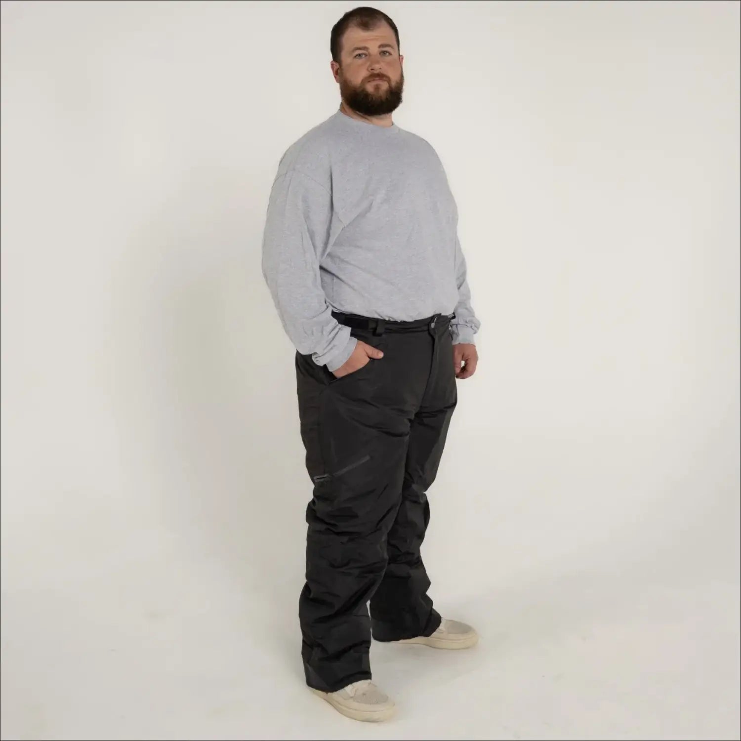 Man wearing gray sweatshirt and black pants in Snow Country Outerwear ski snow pants
