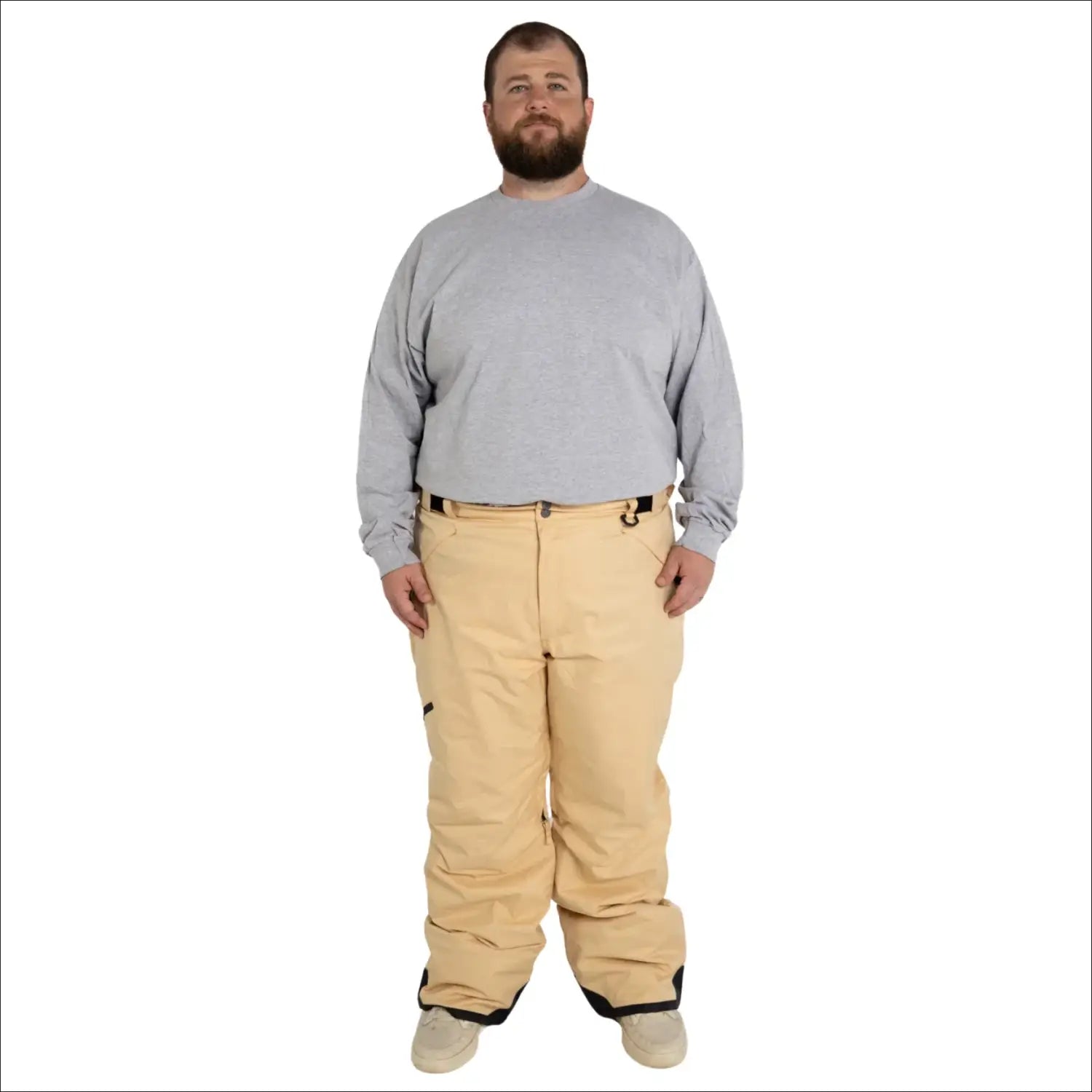 Man wearing tan snow pants and gray shirt in Snow Country Outerwear ski gear
