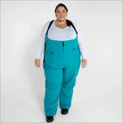 Woman wearing teal Snow Country Outerwear plus size Vertex winter snow ski bibs