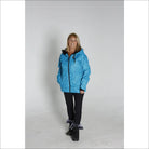 Woman wearing a blue quilted Snow Country Outerwear winter ski coat jacket