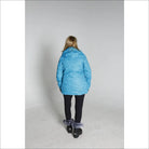 Woman in a blue winter coat, black leggings, and snow boots for Snow Country Outerwear Ski Coat