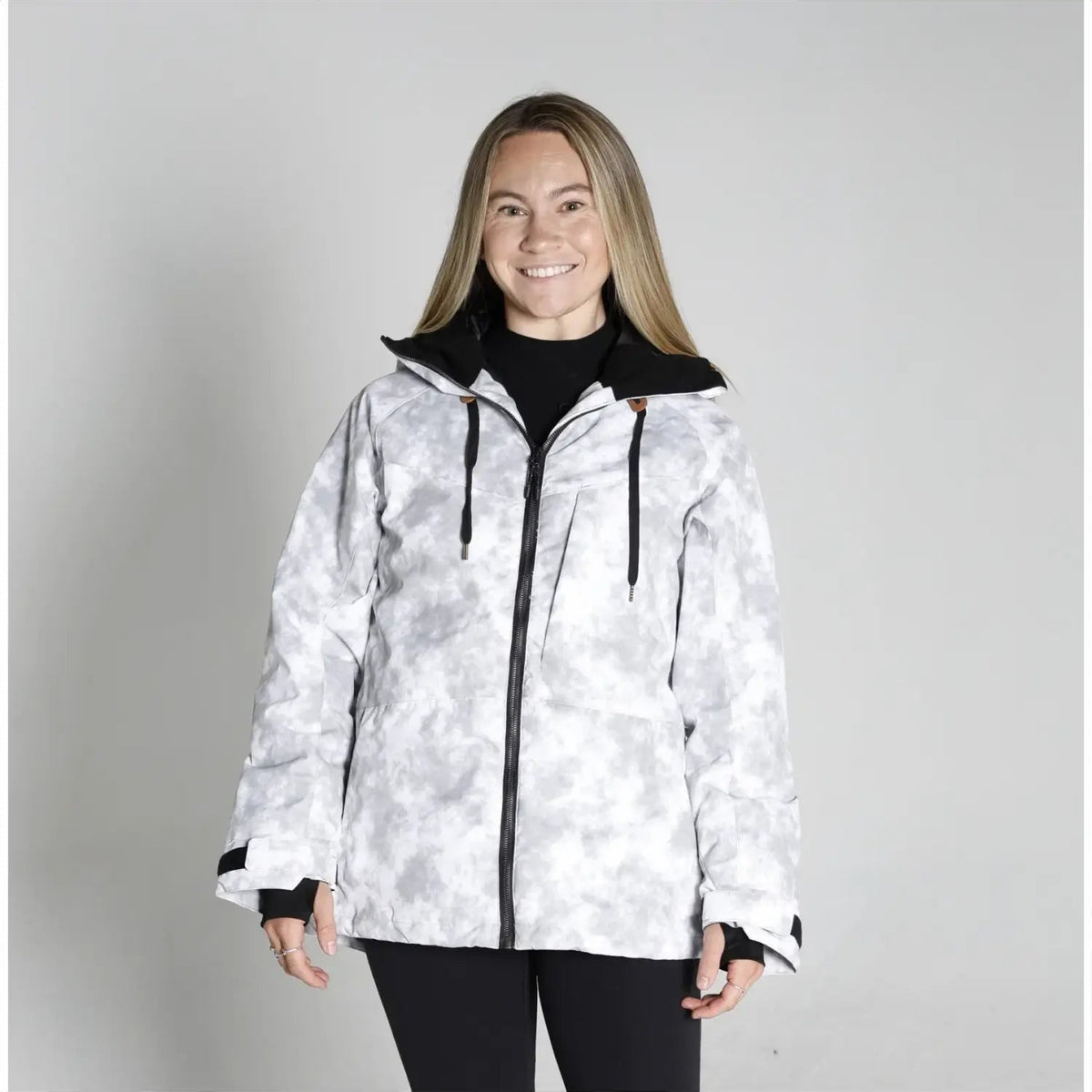 Woman wearing a white camouflage jacket from Snow Country Outerwear for snowboarding and winter skiing