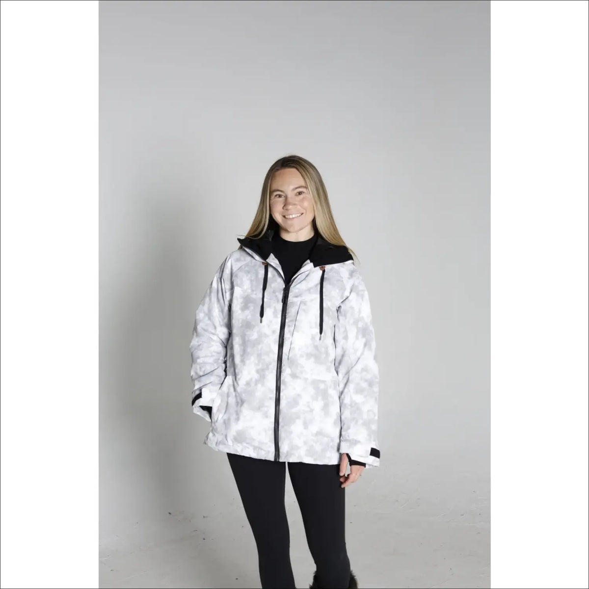 Woman wearing a white and gray camouflage Snow Country Women’s Ski Coat for winter sports